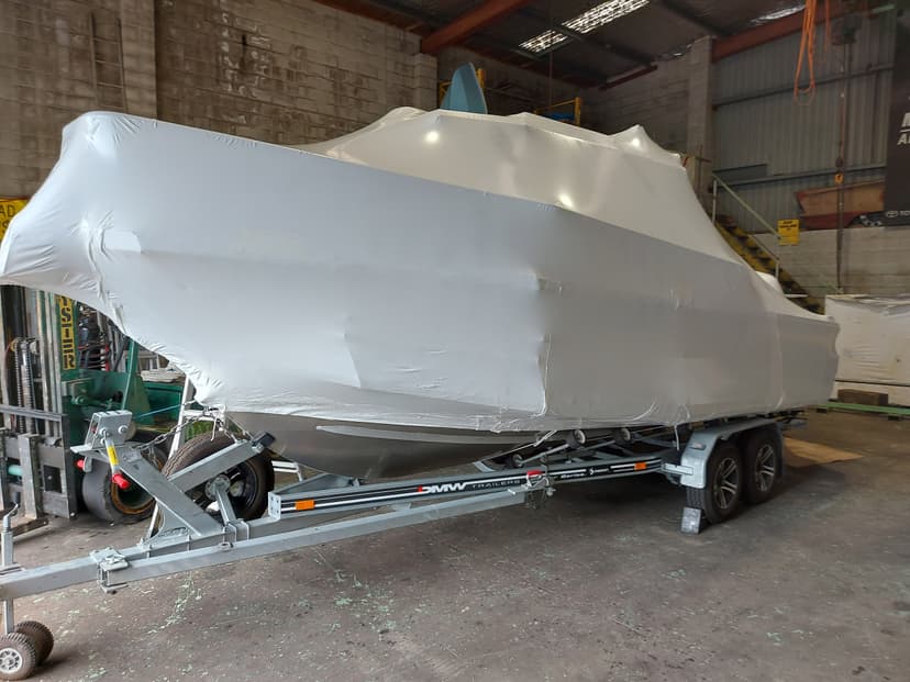 large shrink wrapped boat in boat haulage warehouse