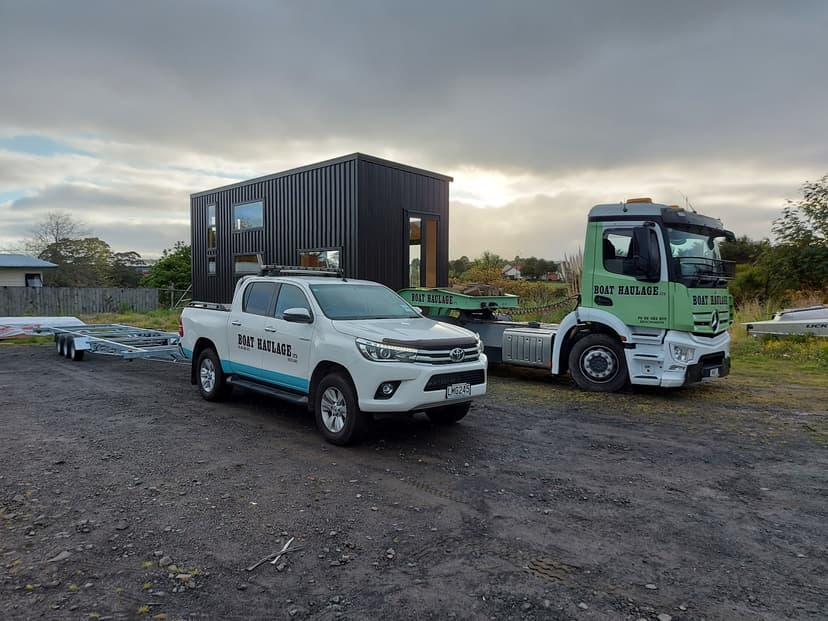 boat haulage moving tiny home with pilot vehicle